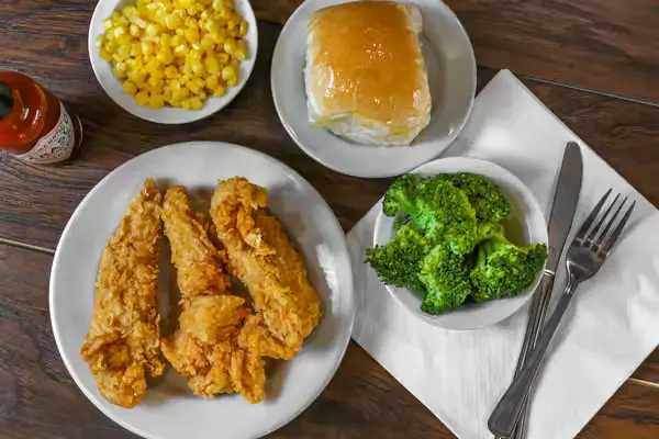 Fried chicken plate with broccoli, corn, and roll